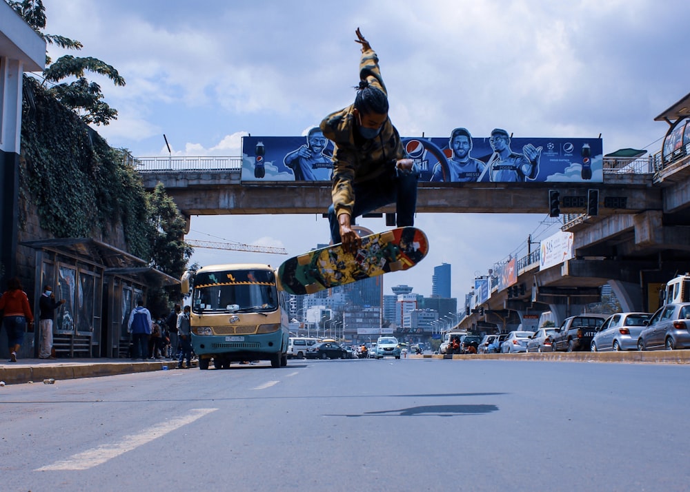 homme en veste noire et pantalon faisant du skateboard sur la route pendant la journée