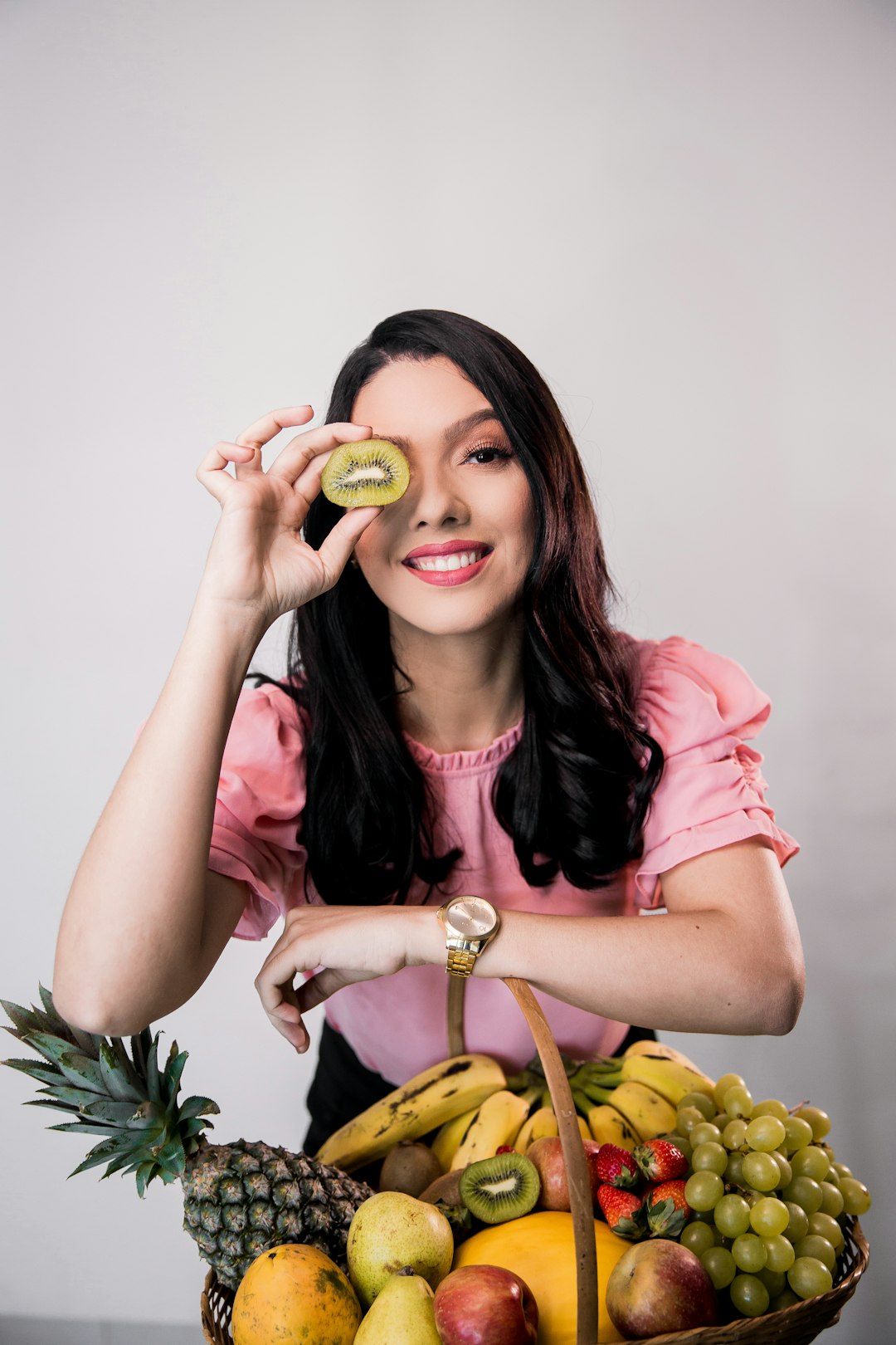 woman in pink long sleeve shirt holding sliced green fruit