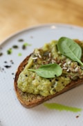 brown bread with green vegetable on white ceramic plate