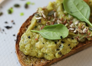 brown bread with green vegetable on white ceramic plate