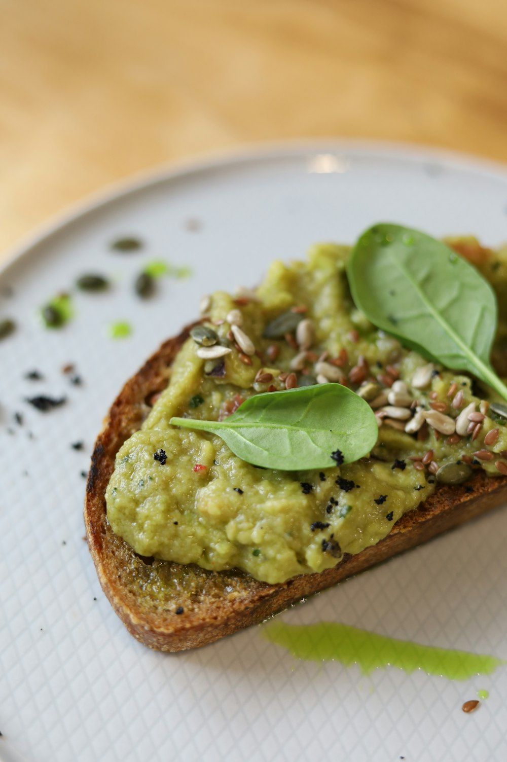 brown bread with green vegetable on white ceramic plate