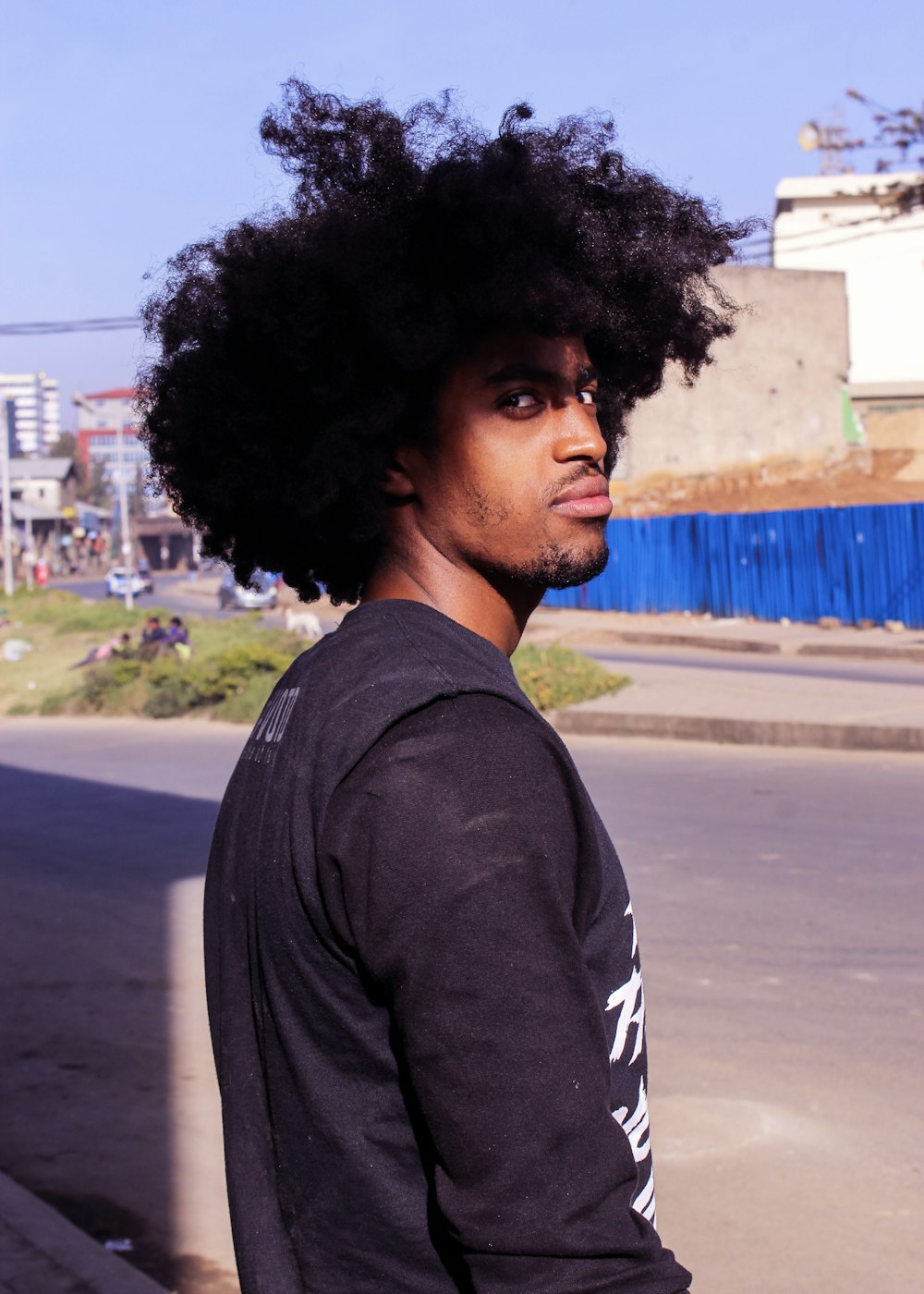 man in black long sleeve shirt standing on road during daytime