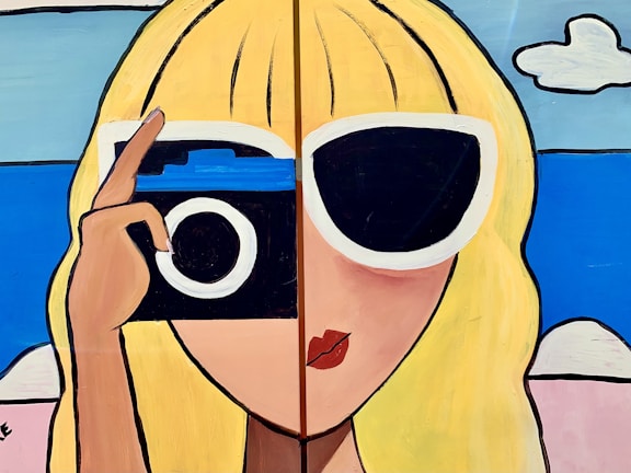 A stylized painting featuring a person with long blonde hair. One eye is covered by large white-framed sunglasses and the other by a classic camera. The background includes a blue sky and clouds, suggesting a sunny day. The artwork uses bold black outlines and bright colors, contributing to a pop-art style.