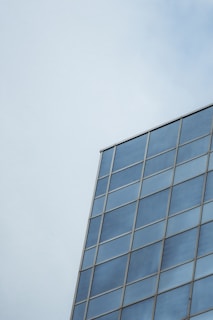 Close-up of modern glass building reflecting blue sky