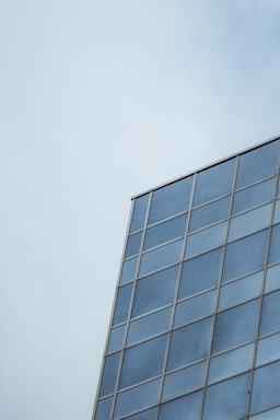 Close-up of modern glass building reflecting blue sky