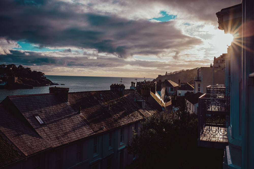 houses near sea under cloudy sky during daytime