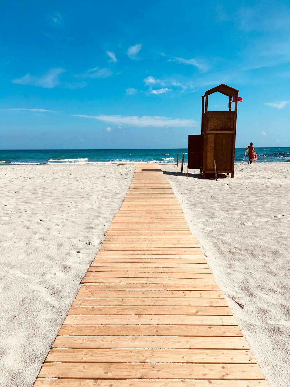 brown wooden dock on white sand beach during daytime