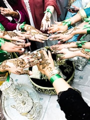 Hands decorated with colorful mendhi patterns during a festive celebration