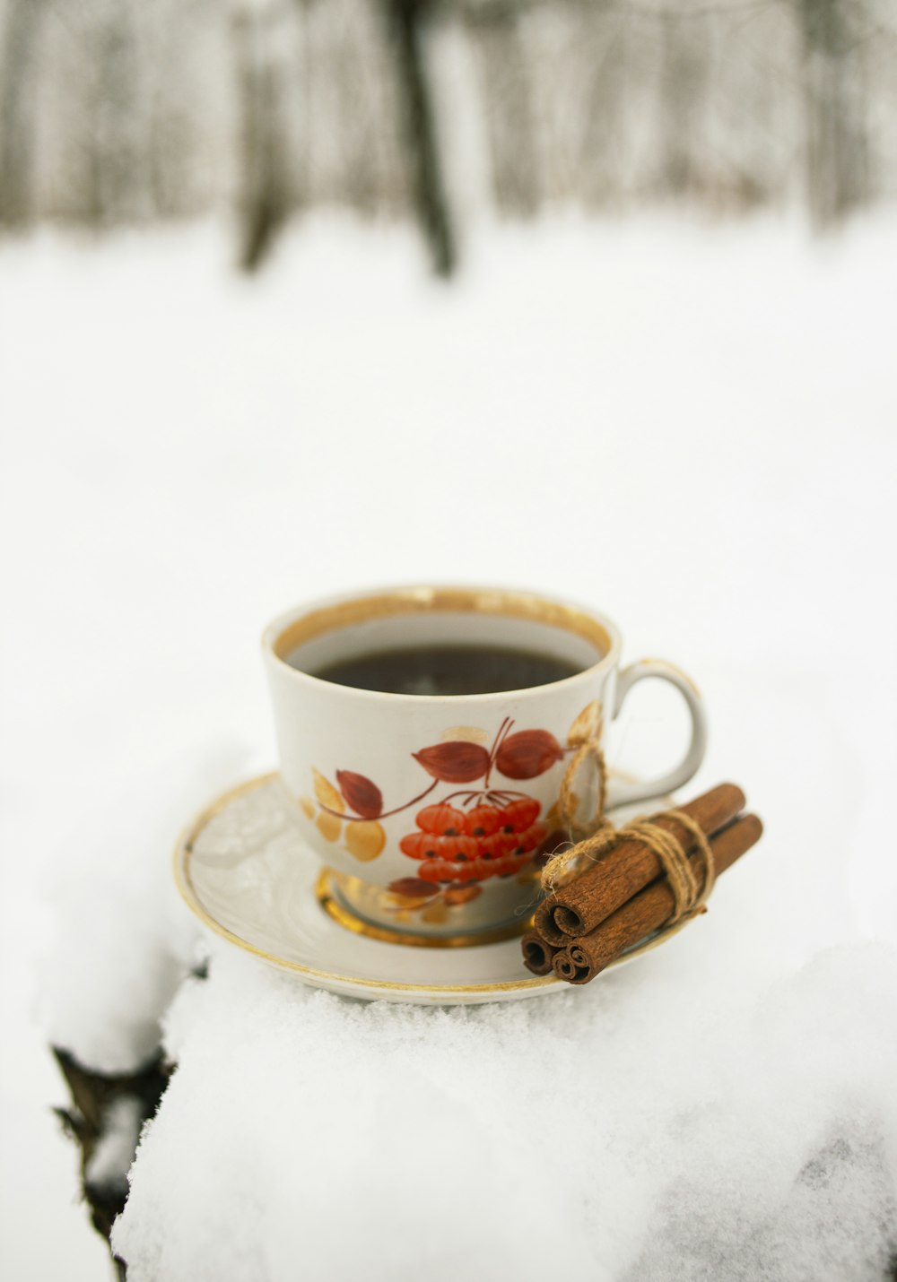 white and red floral ceramic teacup on saucer