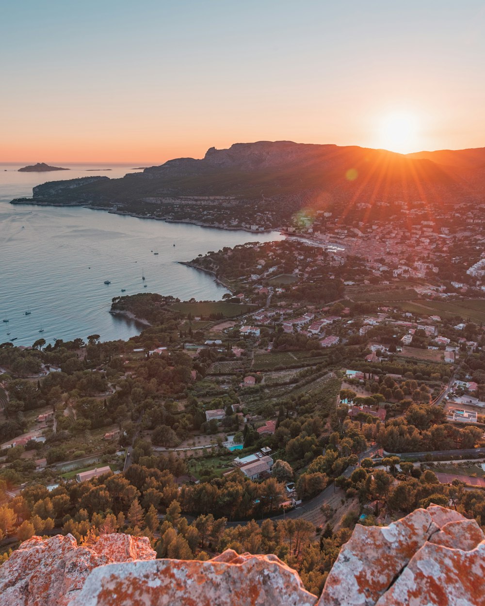 aerial view of city near body of water during sunset