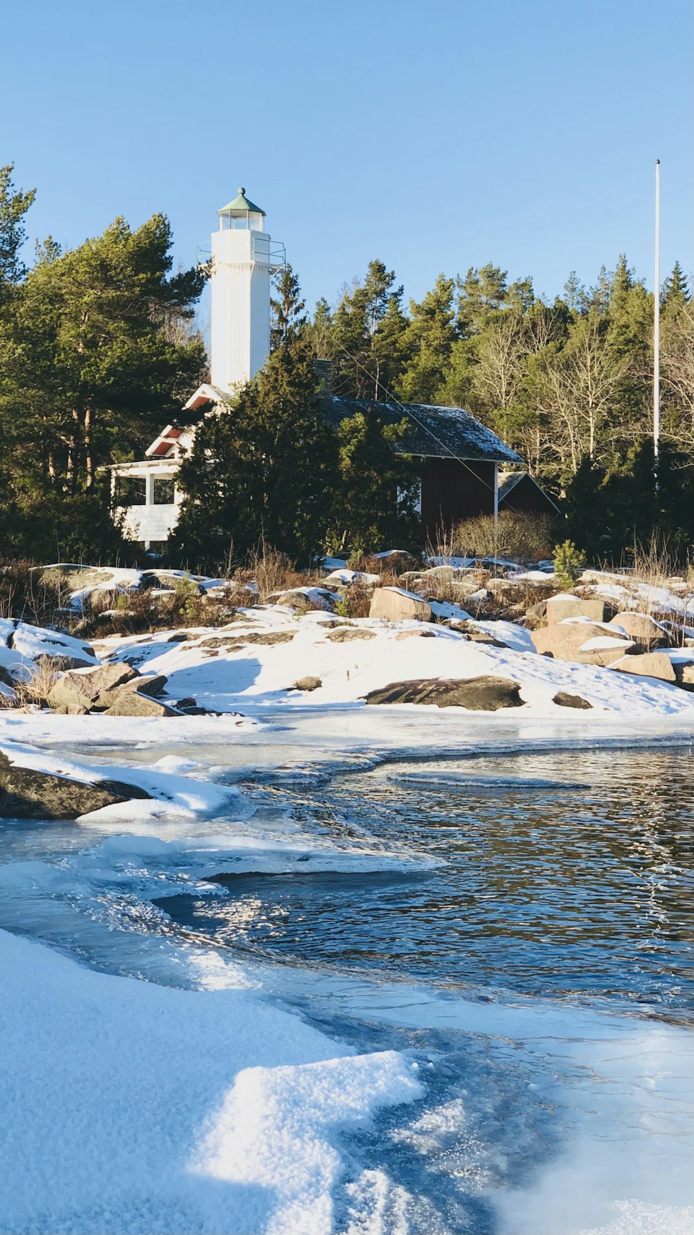 white and brown house near body of water during daytime