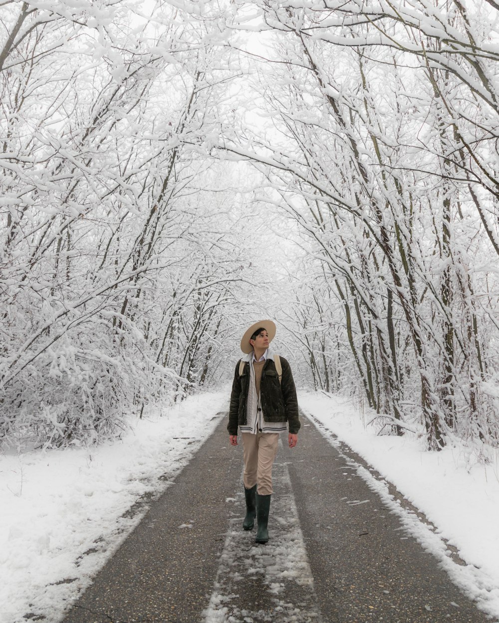 A young man looking around his snow-capped surroundings on a beautiful winter day