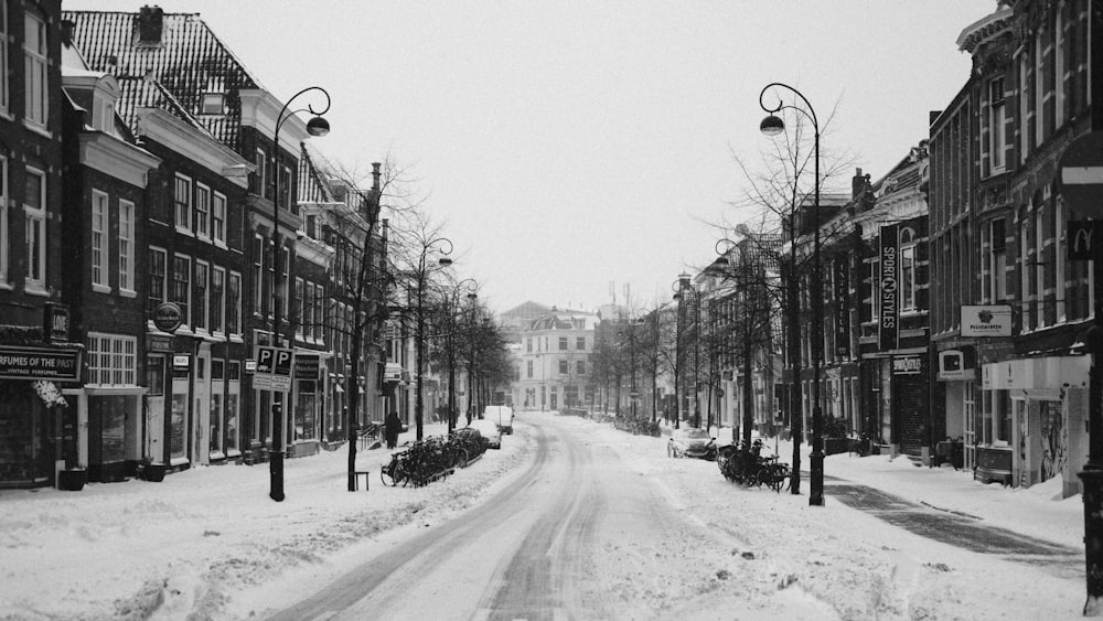 grayscale photo of road between buildings