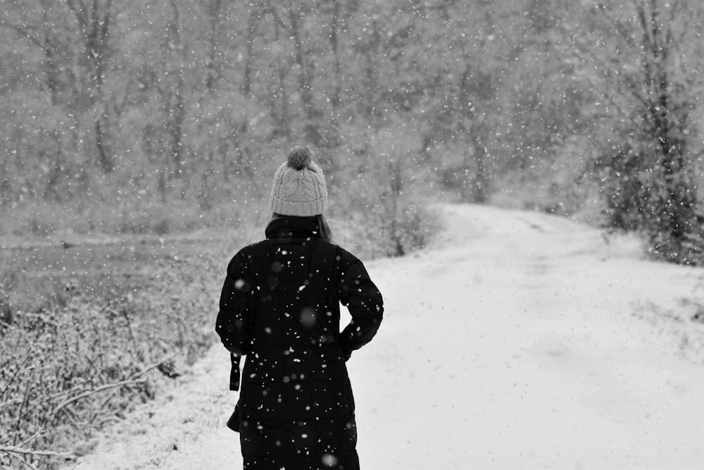 person in black coat standing on snow covered ground