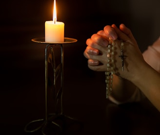 person holding white pillar candle