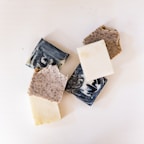 A collection of handmade soaps displayed on a rustic shelf.