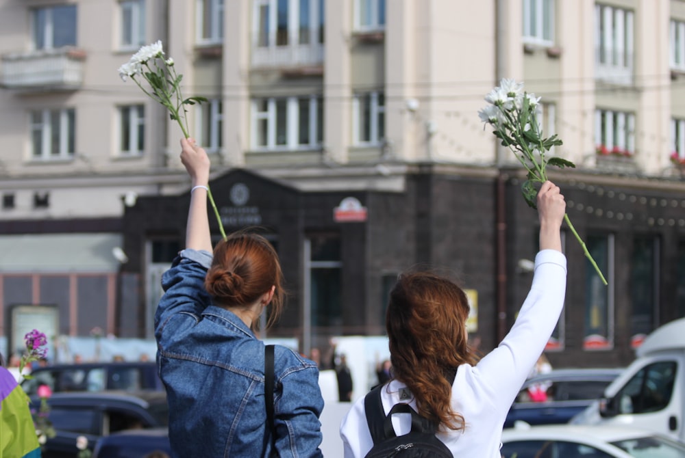 woman in blue jacket holding green plant