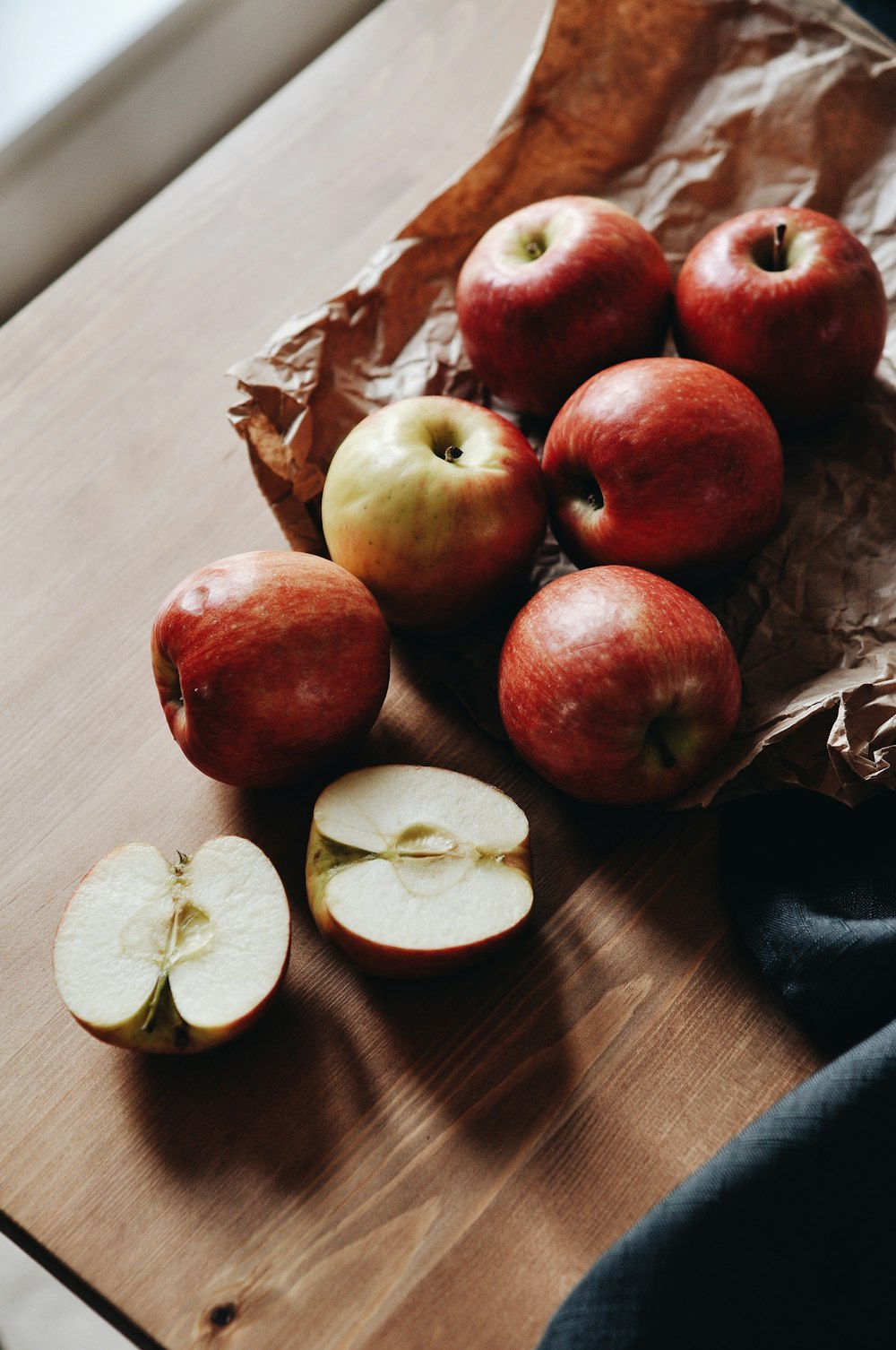 red apples and sliced lemon on brown paper bag