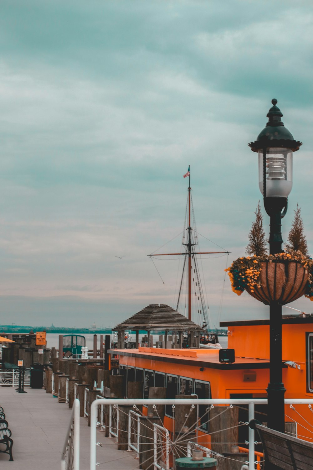 black and brown street lamp near brown and white boat during daytime