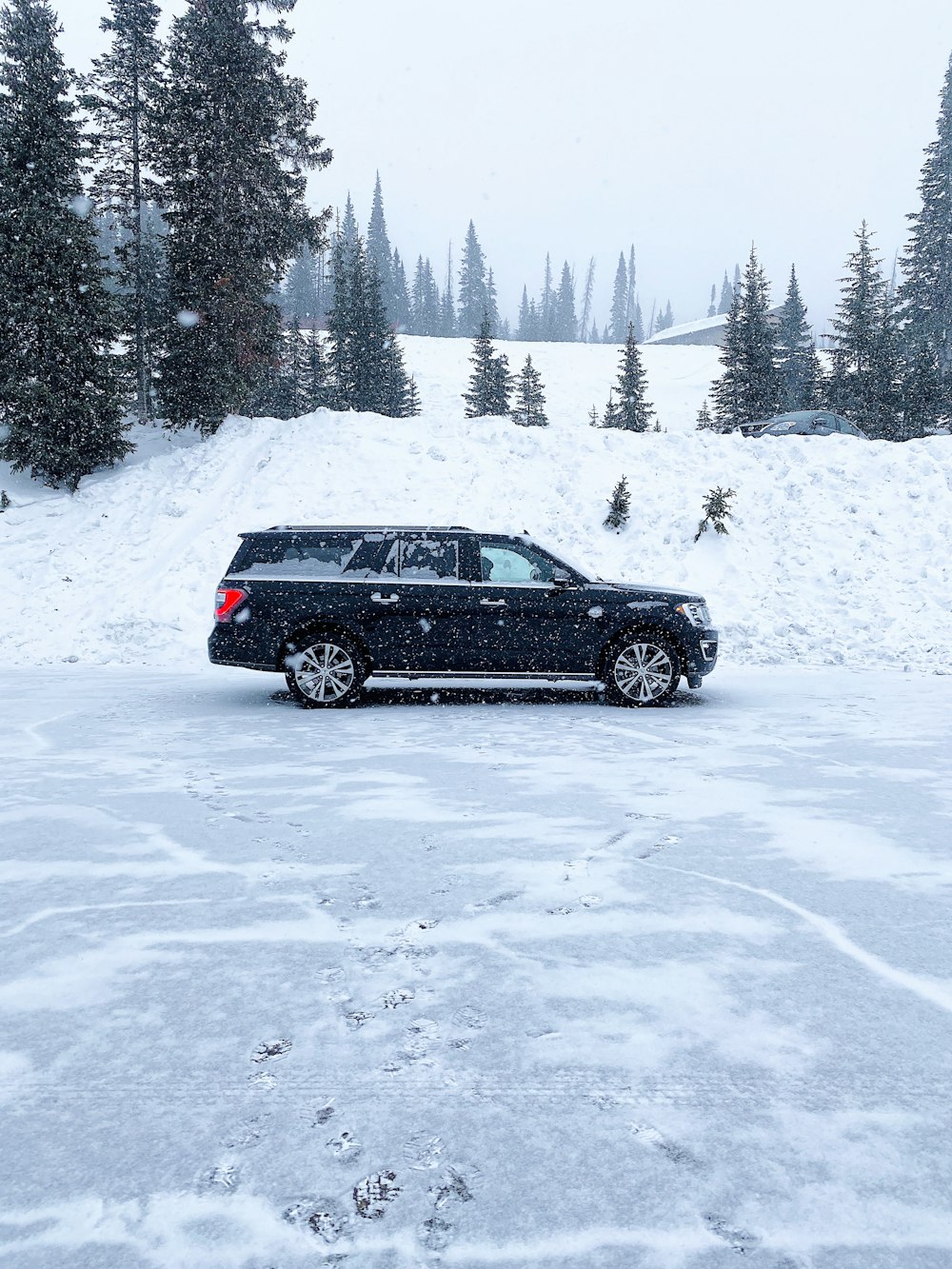 Schwarzer SUV auf schneebedecktem Untergrund