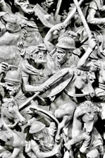 gray scale photo of man holding sword statue