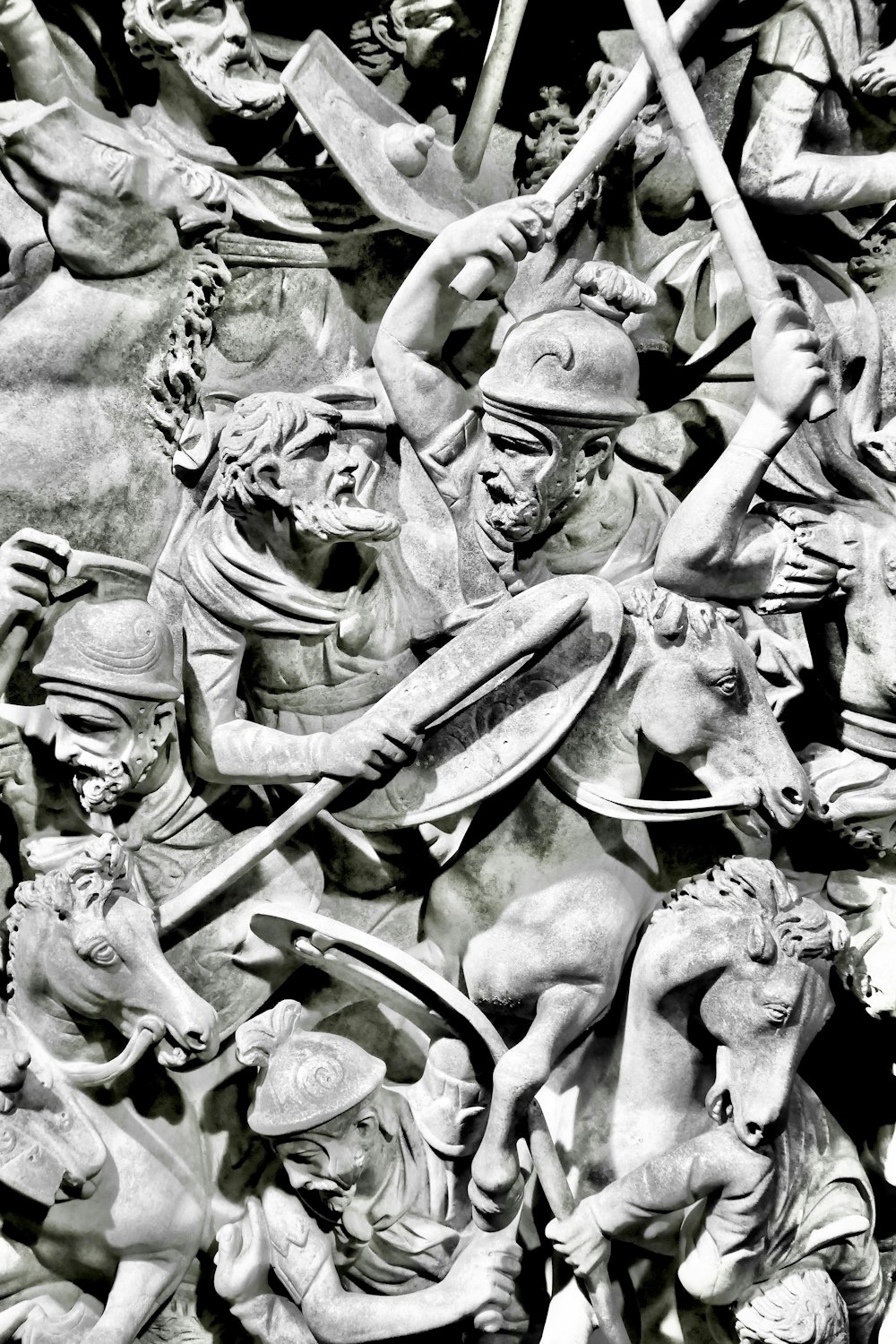 Foto en escala de grises de hombre sosteniendo estatua de espada