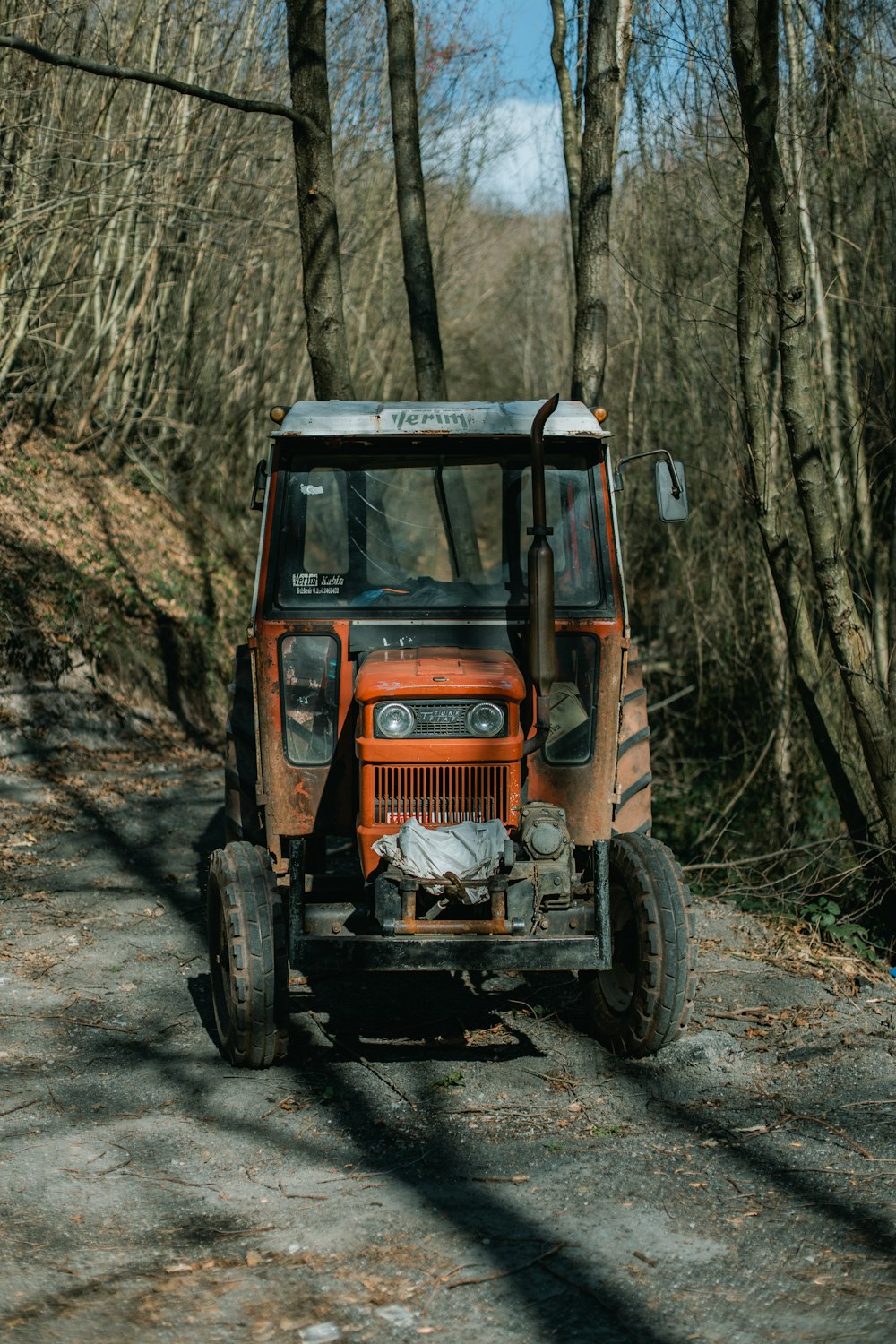 orange tractor in the middle of the woods
