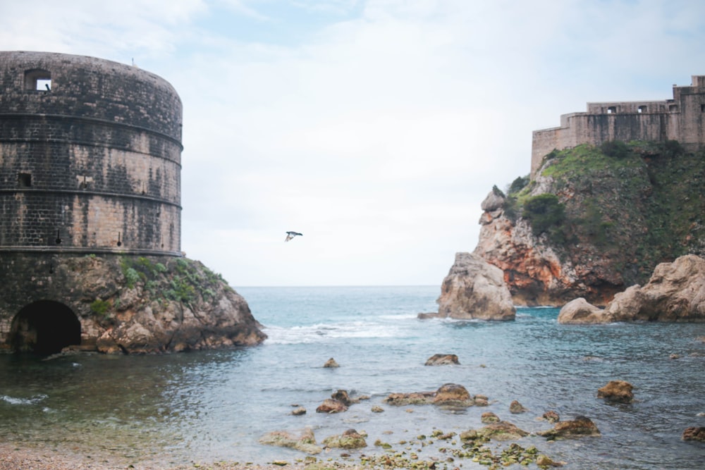 Bâtiment en béton brun près d’un plan d’eau pendant la journée