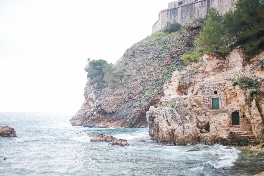 昼間の海辺の崖の上の茶色のコンクリートの建物