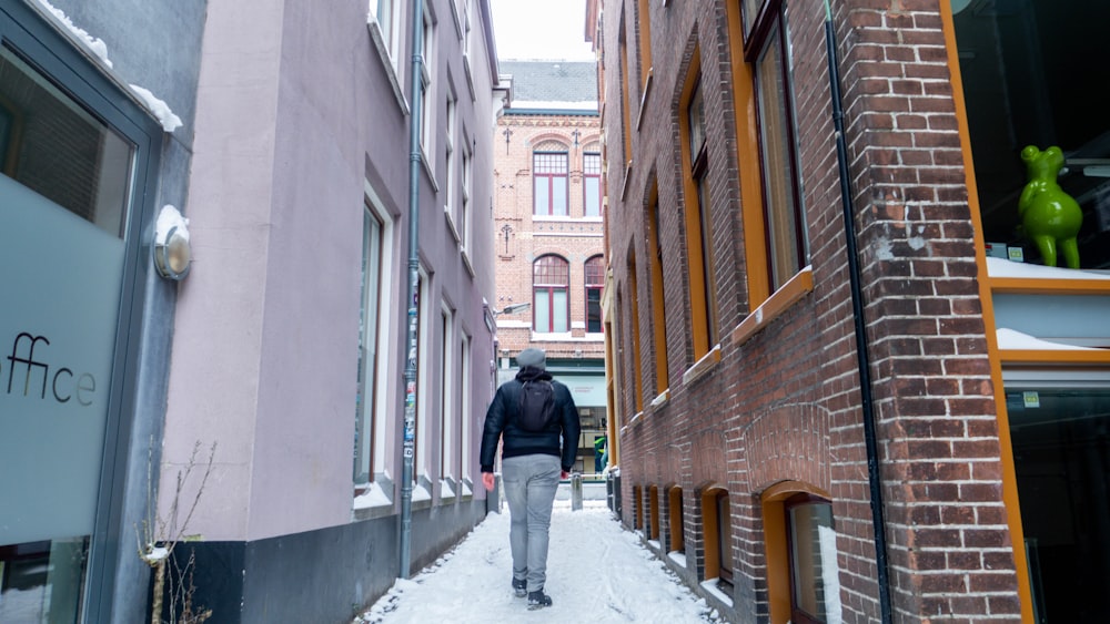 Person in schwarzer Jacke, die tagsüber auf dem Bürgersteig geht