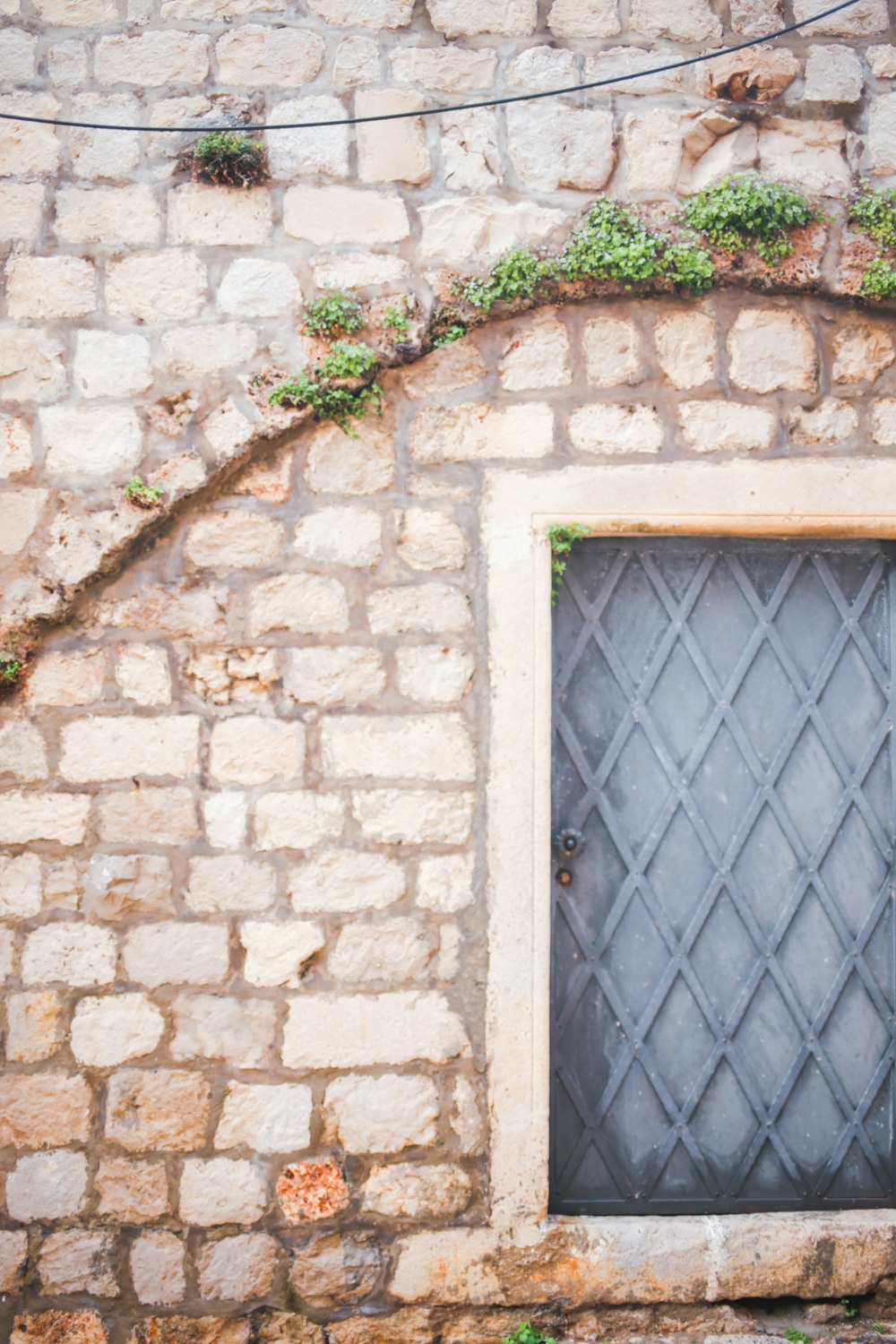 brown brick wall with blue metal window