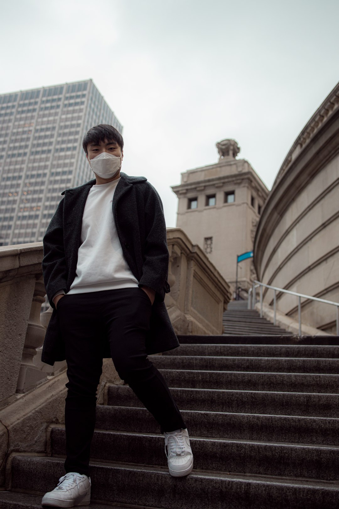 man in black jacket and black pants standing on stairs