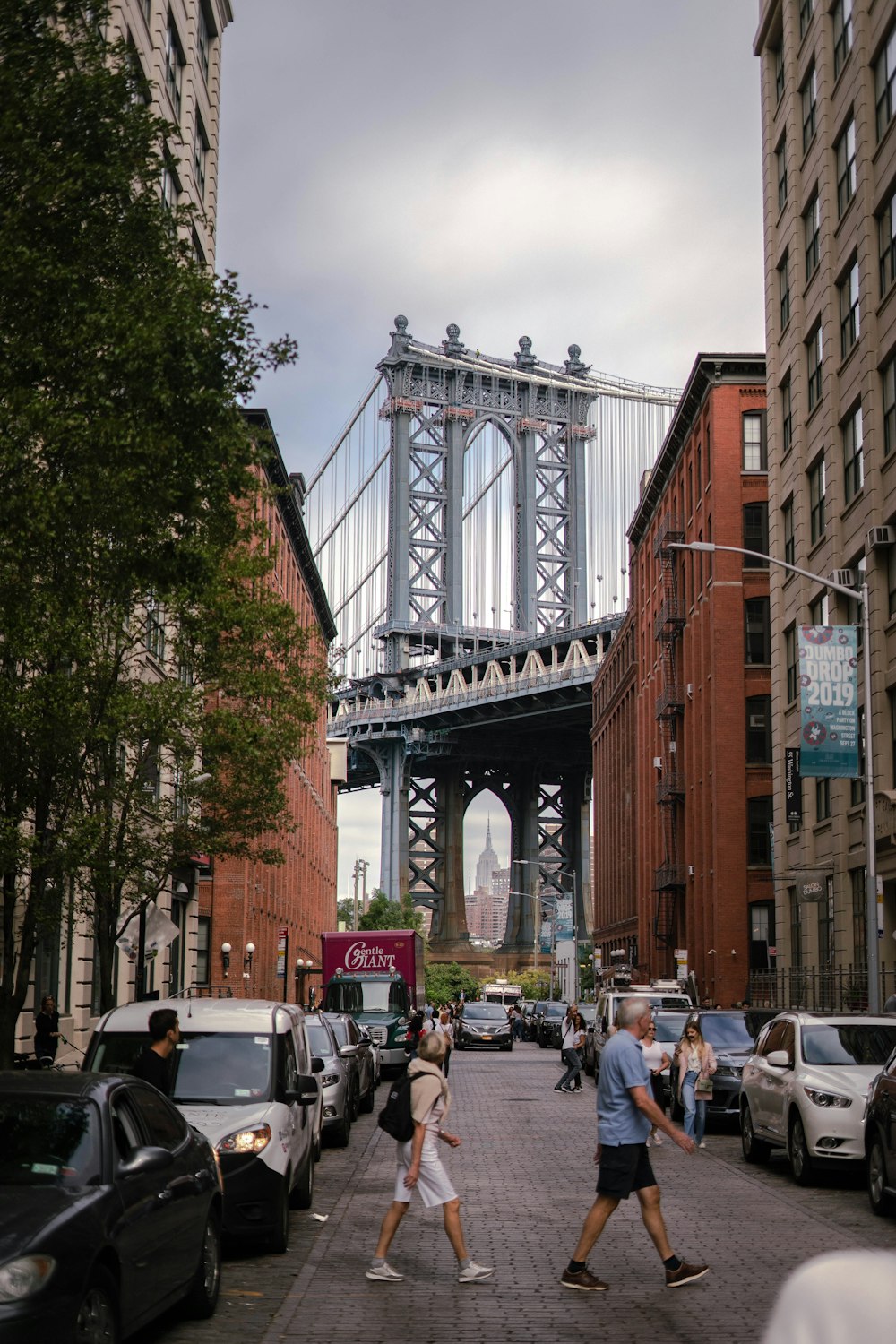 people walking on the street near the bridge during daytime