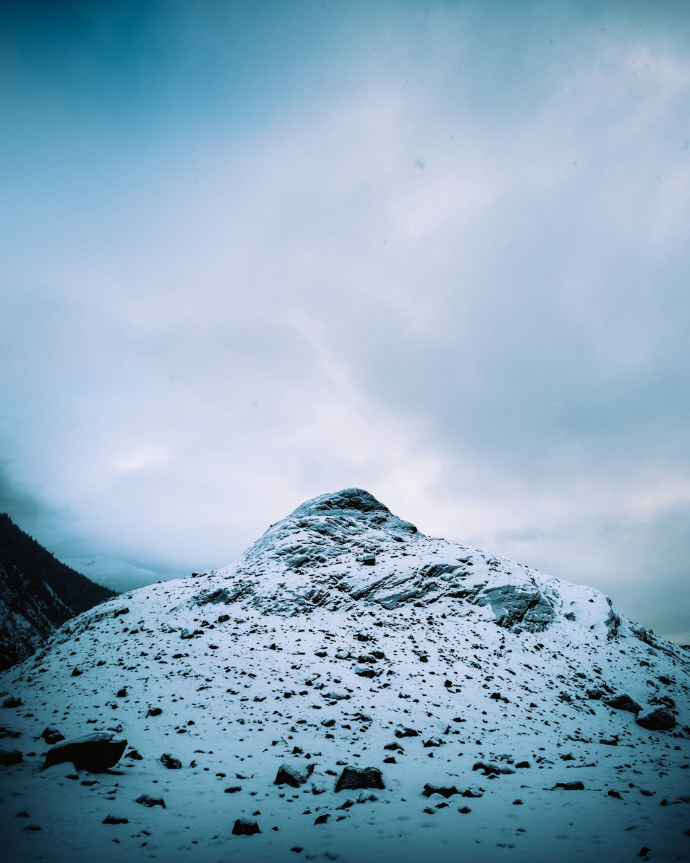 snow covered mountain under cloudy sky during daytime