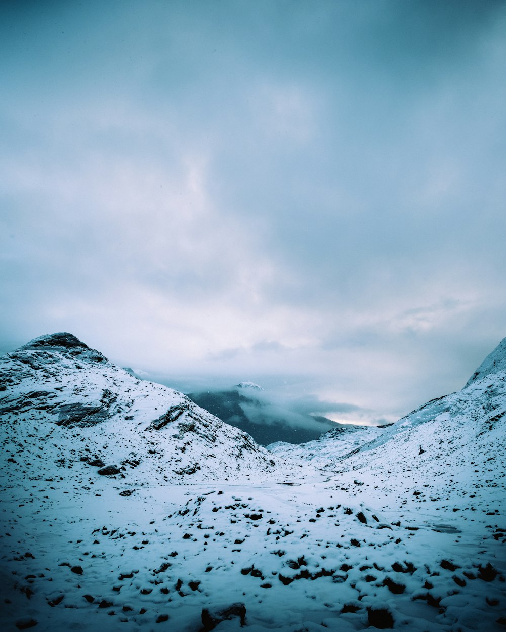 snow covered mountain under cloudy sky during daytime