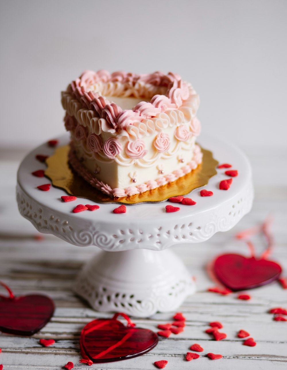 pink and white cupcake on white and red heart shaped ceramic plate
