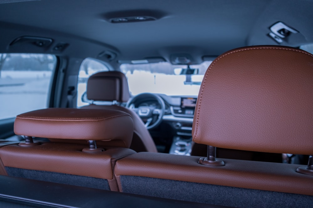 the inside of a vehicle with a brown leather seat