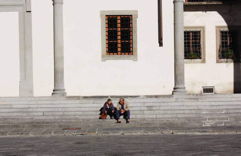 woman in black jacket sitting on concrete bench