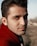 man in red hoodie standing on brown field during daytime