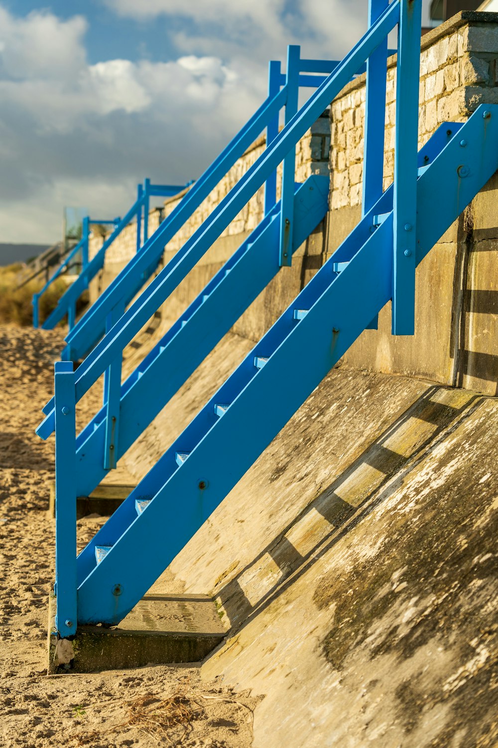 blau-weißer Holzzaun auf braunem Sand tagsüber