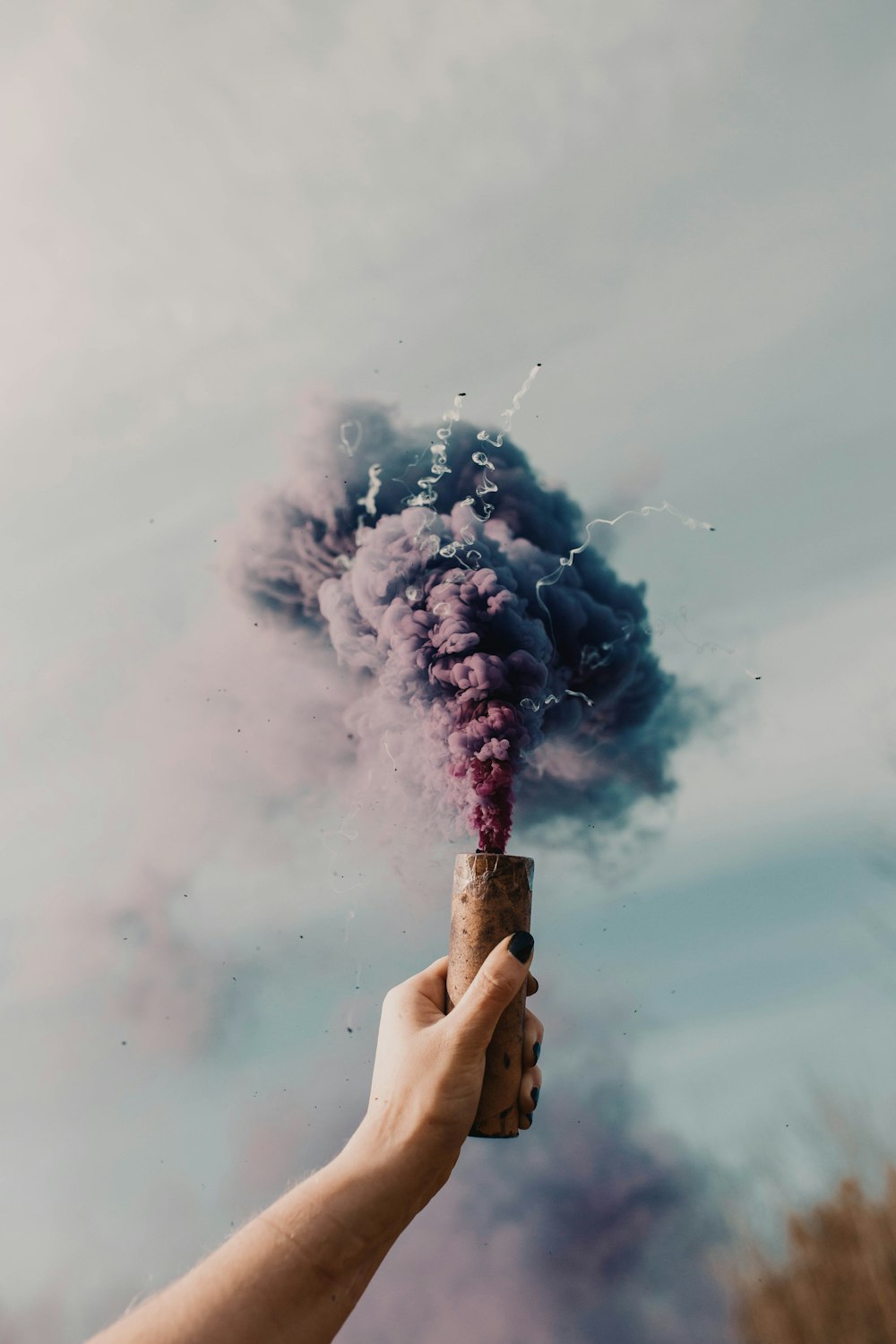 person holding white smoke on his face