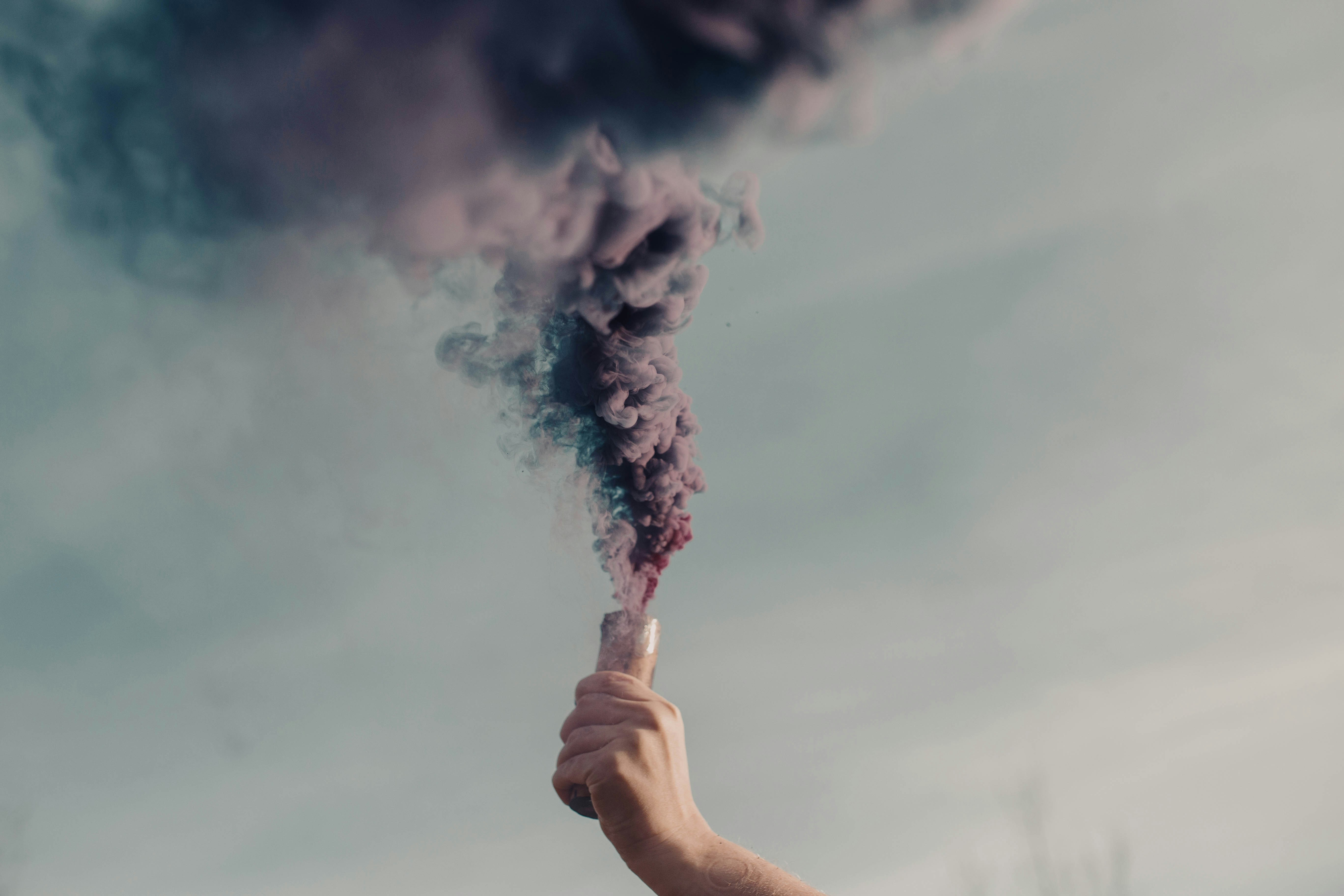 Persona sosteniendo humo blanco durante el día