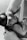 A black and white image of an infant breastfeeding. The baby is wearing a delicate headband and is held gently. The adult's arm is visible, cradling the child in a nurturing manner.