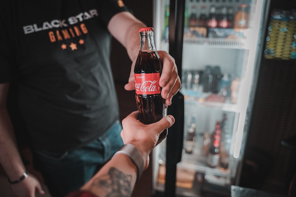 Person mit einer Coca-Cola-Flasche