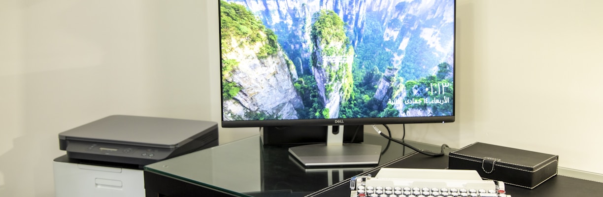 black flat screen tv turned on near white computer keyboard