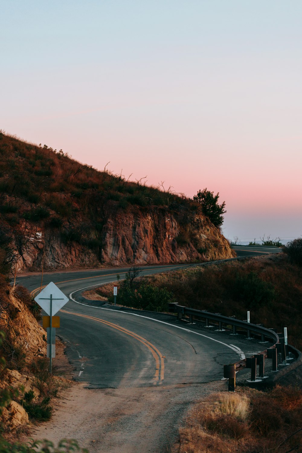 black asphalt road near brown mountain during daytime