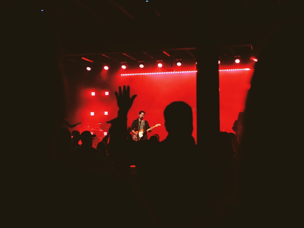 man in black shirt playing guitar on stage