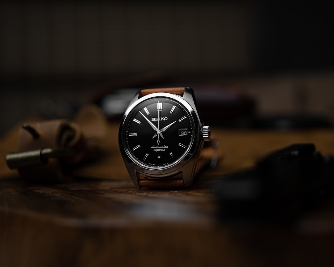 silver and black analog watch, Seiko Sarb033 on natural brown leather strap, with canvas and leather messenger bag.