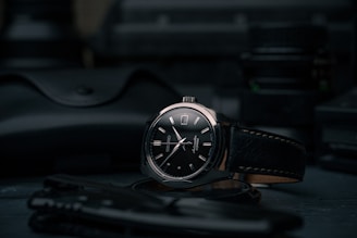 black and silver round analog watch