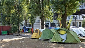 Volunteers setting up informational booths with mental health resources in a sunny park.